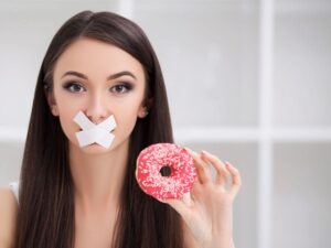 donna con ciambella e cerotto sulla bocca